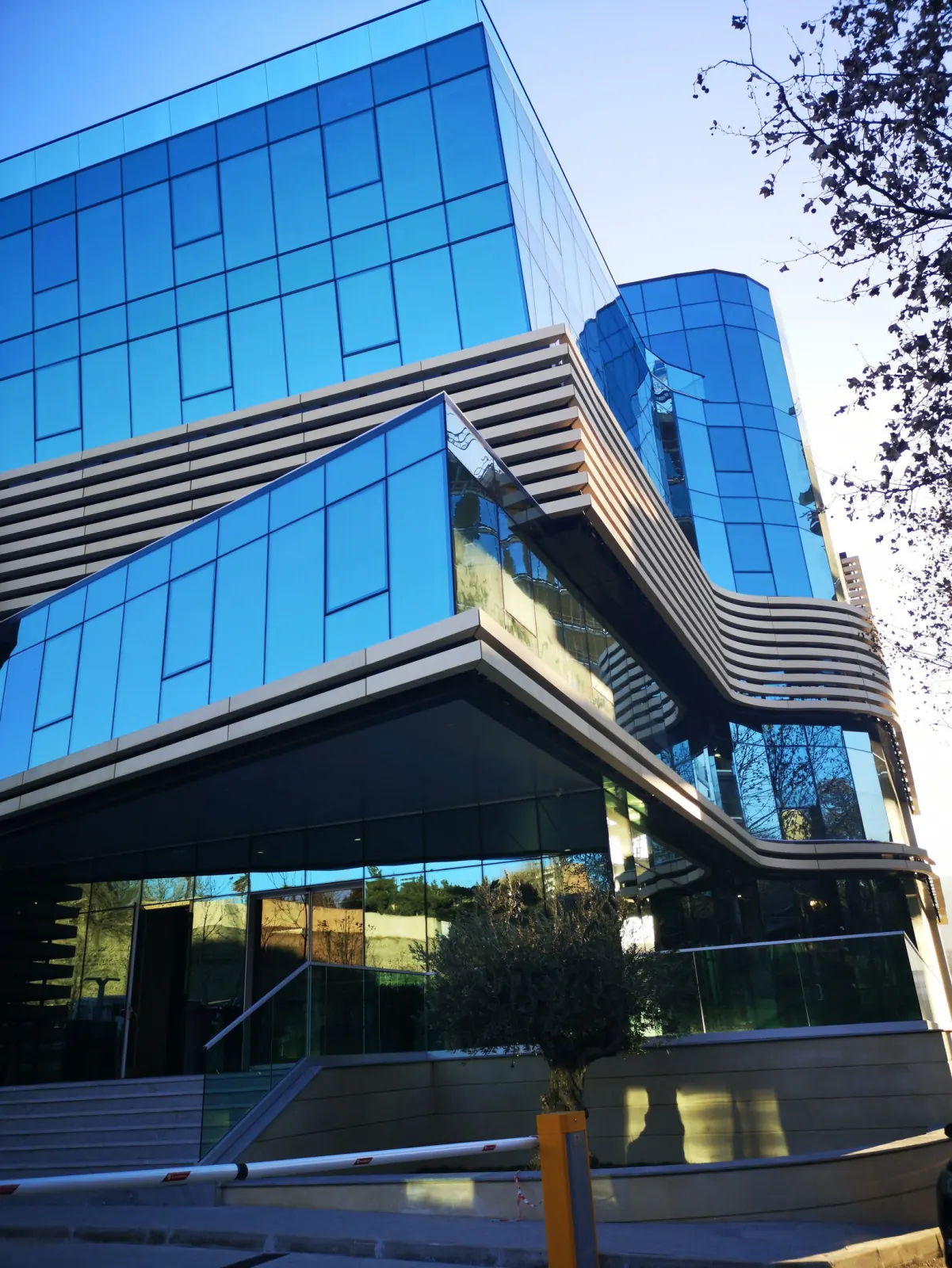 Tbilisi Business Center (Exterior) — Full height architectural facade perspective emphasizing vertical rhythm, cantilevered volumes, and dark mullions
